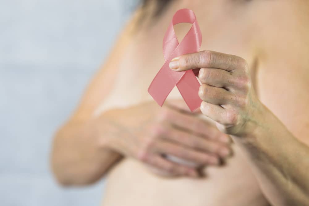 Frau mit dem Pink Ribbon als Symbol für Brustkrebsvorsorge