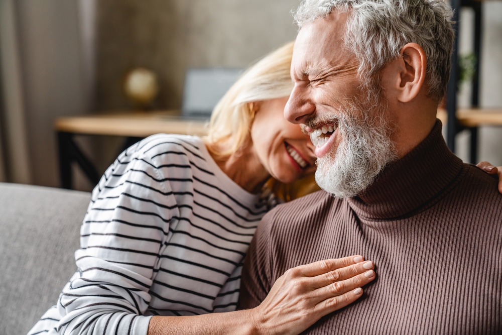 Happy woman puts her hand towards the heart of a happy man