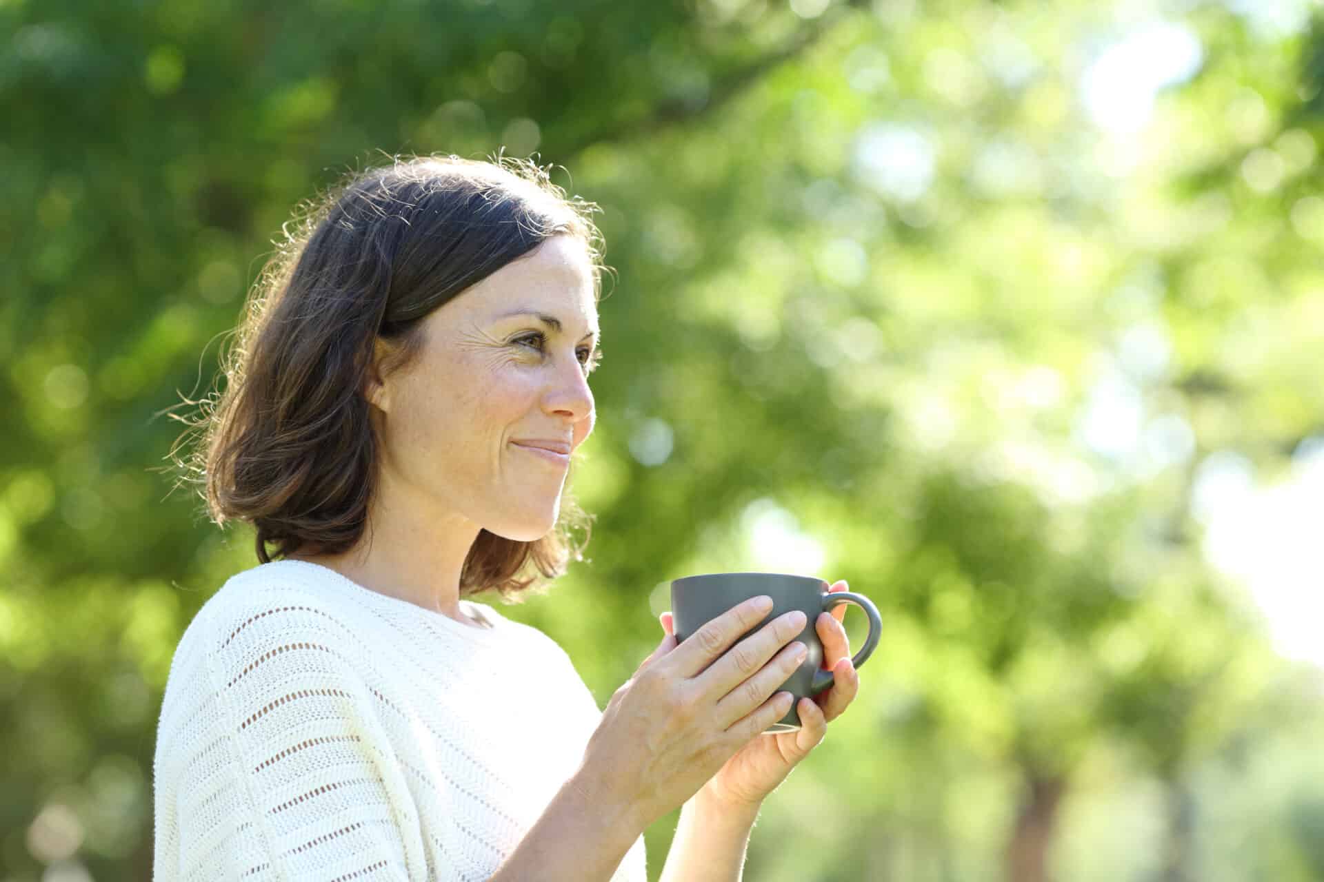 Frau genießt grünen Tee in der Natur