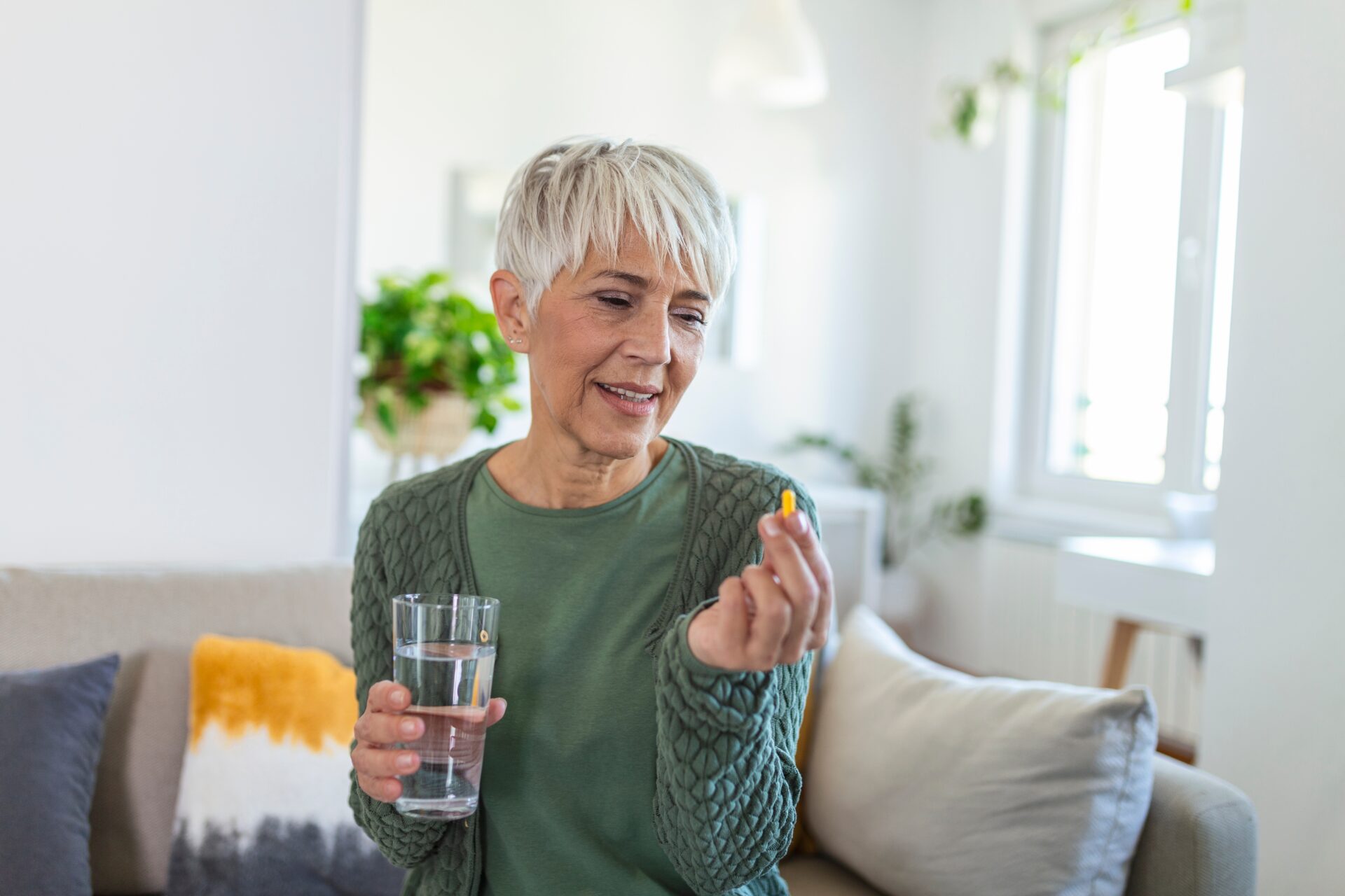 Smiling mature woman taking a pill