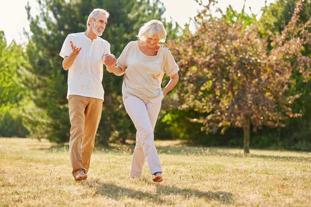 An elderly couple exercise in the great outdoors to prevent Alzheimer's disease